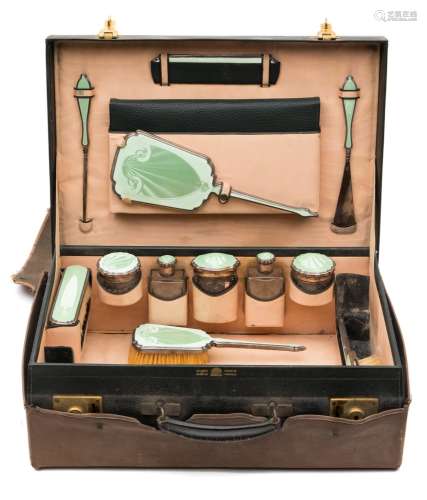 A George V green leather travelling vanity case: containing silver and green enamel mounted jars,