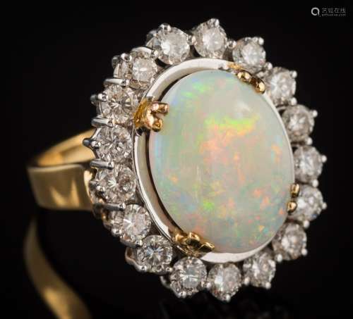 An opal and diamond oval cluster ring: the oval opal approximately 15.9mm long x 12.