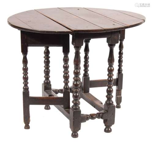 An early 18th Century oak oval gateleg table:, the hinged top on bobbin turned legs,