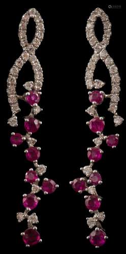 A pair of modern ruby and diamond pendant earrings: with stylised openwork ribbons suspending