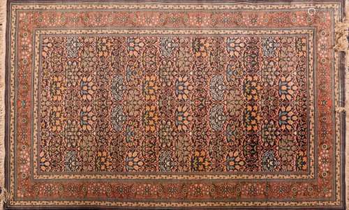 A Qum rug:, the indigo field with all over palmette and flowering stems in ogee surrounds,