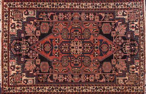 A Qashgai rug:, the shaded field with a brick red pointed medallion and geometric designs,