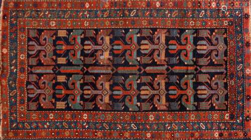 A Kurdish fertility rug:, the indigo field with two rows of hooked geometric medallions,