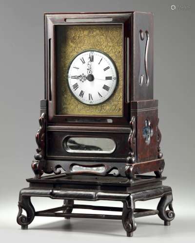A CHINESE GILT BRONZE TABLE CLOCK IN A HONGMU CASE AND STAND