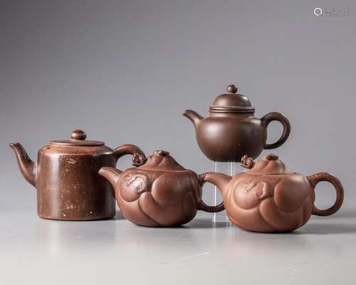 A GROUP OF FOUR CHINESE YIXING TEAPOTS AND A BROWN GLAZED TEAPOT