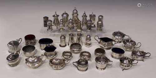 A collection of silver condiments, including pepper casters, mustards and salts, various dates and