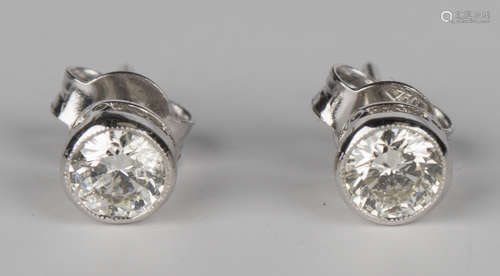 A pair of white gold and diamond single stone earstuds, each collet set with a circular cut diamond,