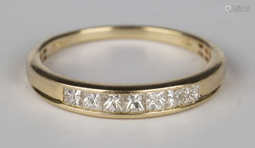 A 14k gold and diamond seven stone half-hoop ring, mounted with a row of princess cut diamonds, ring