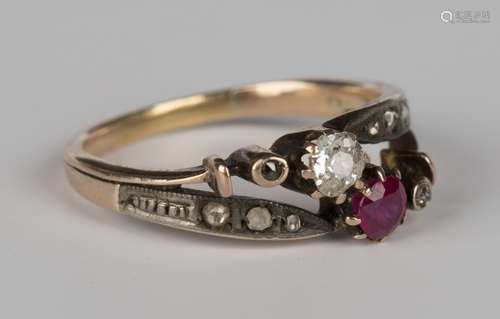 A gold, diamond and ruby ring in a twist design, claw set with the principal cushion shaped