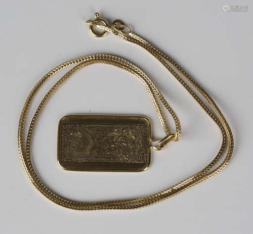 A gold rectangular pendant, modelled as a United Arab Emirates Currency Board ten dirhams