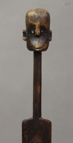 An African carved hardwood figure of elongated form, raised on a stepped base, height 153cm.Buyer’