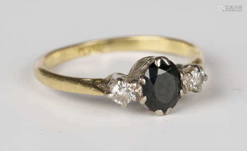 A gold, sapphire and diamond three stone ring, claw set with the oval cut sapphire between two