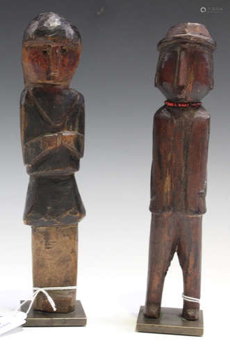 A pair of African carved wooden full-length figures, modelled depicting male and female Europeans,