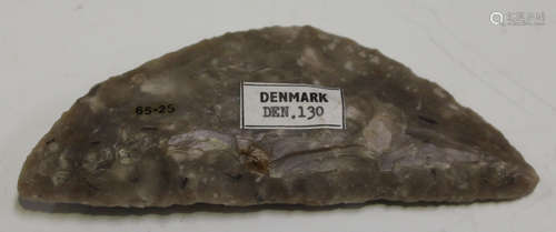 A Danish Neolithic flint sickle blade of shaped half-moon form, bearing collection label marked '