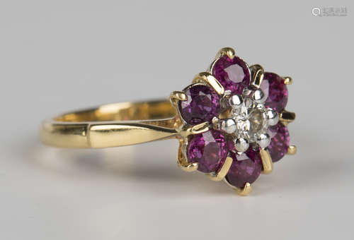 A gold, diamond and ruby seven stone cluster ring, claw set with the circular cut diamond within a