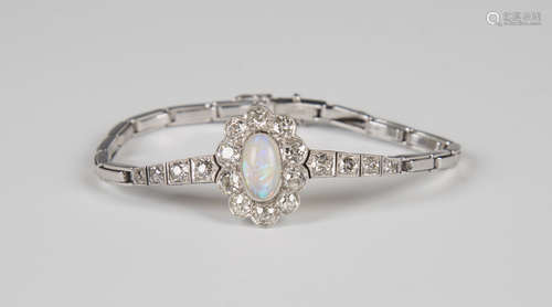 A platinum, diamond and opal bracelet, the front set with an oval cluster, collet set with an oval