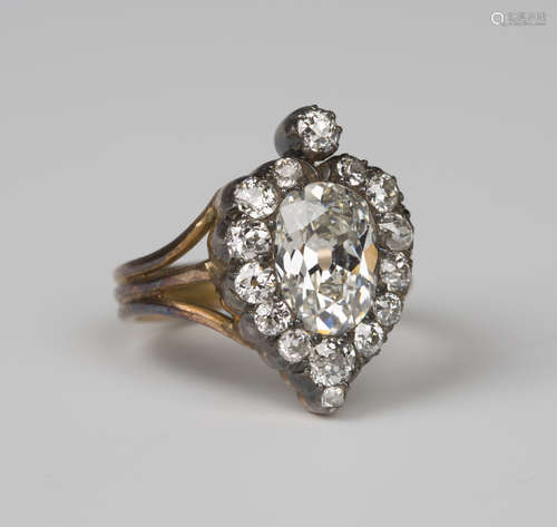 A diamond ring, mounted with the principal oval old cut diamond within a stylized heart shaped