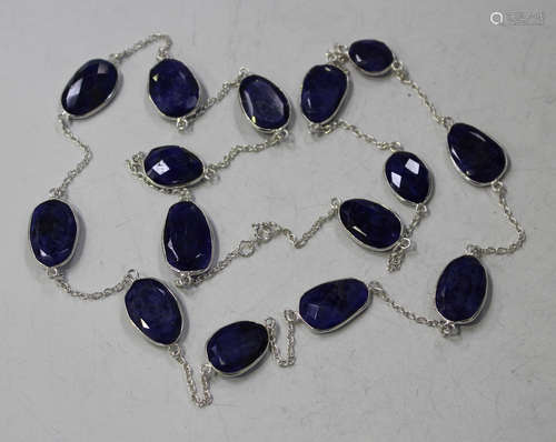 A silver and treated reconstituted sapphire necklace, the oval link chain spaced with spectacle