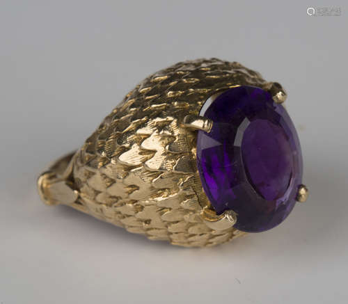 A 9ct gold ring, claw set with an oval cut amethyst within a raised foliate surround, London 1967,