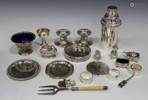 A group of plated items, including a cocktail shaker, wine coaster and various cutlery, including