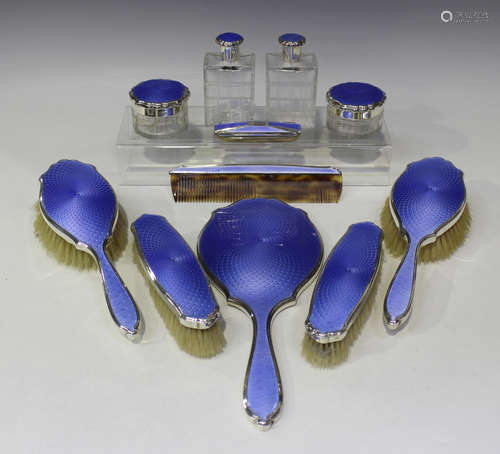 A silver and blue enamelled ten-piece dressing table set, comprising a hand mirror, two hairbrushes,