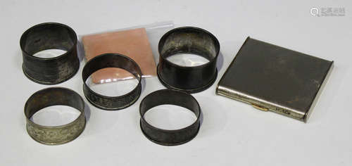 Four silver napkin rings, a silver square powder compact, and another napkin ring.Buyer’s Premium