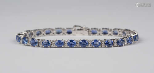 An 18ct white gold, sapphire and diamond line bracelet, claw set with oval cut sapphires alternating