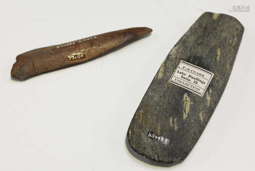 A small Neolithic polished stone axe head, bearing 'F.S. Clark Lake Dwellings Collection' label,