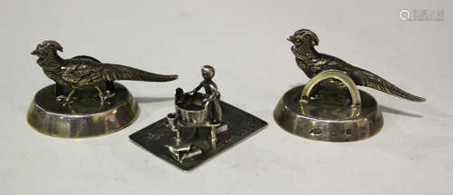 A pair of George V silver menu holders, each oval base surmounted with a pheasant, Chester 1914 by