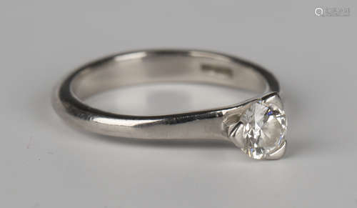 A platinum and diamond single stone ring, claw set with a circular cut diamond in a three claw