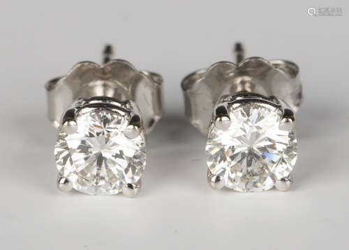 A pair of white gold and diamond single stone earrings, each claw set with a circular cut diamond,