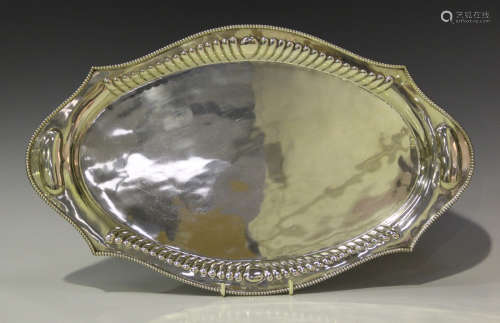 An early 20th century Indian silver shaped oval two-handled tray with reeded sides and beaded rim,