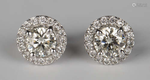 A pair of white gold and diamond cluster earstuds, each claw set with the principal circular cut