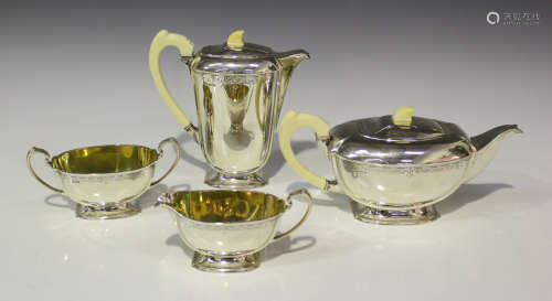A George VI silver four-piece tea set of oval form, engraved with a foliate band, comprising