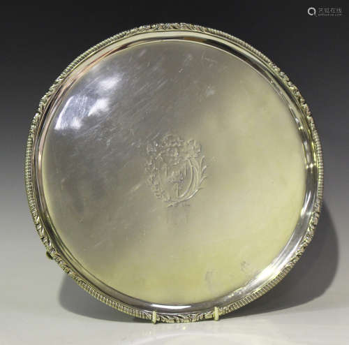 A George III silver circular salver, engraved with a coat of arms within a scroll and gadrooned rim,