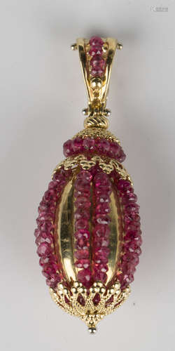 A gold and ruby pendant, the oval body mounted with eight rows of facet cut ruby beads with a