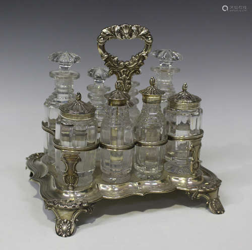 A William IV silver shaped rectangular eight bottle cruet stand, the foliate scroll handle above