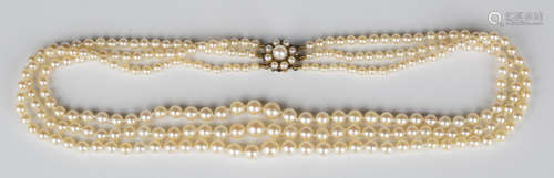 A three row necklace of graduated cultured pearls on a cultured pearl cluster clasp, length of