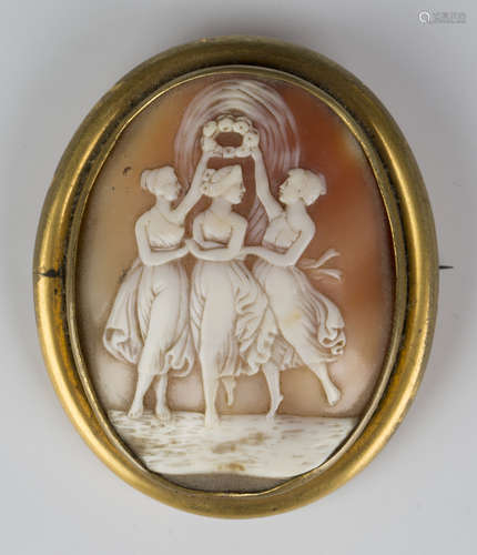 A gilt metal mounted oval shell cameo brooch, carved as the Three Graces, width 5.5cm.Buyer’s