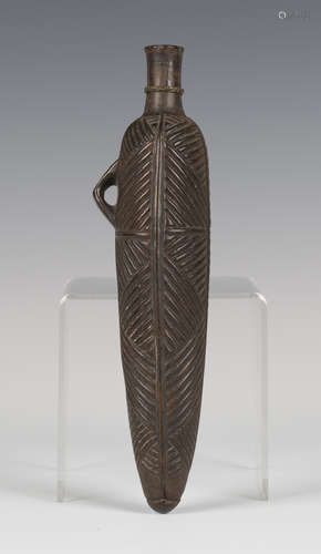 A 19th century Zulu carved hardwood powder flask of elongated ovoid form, carved in relief with