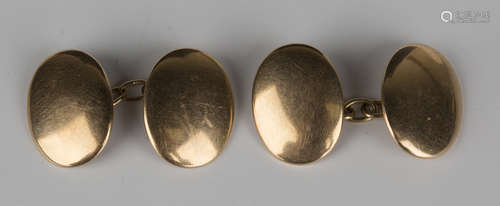 A pair of gold cufflinks, each with a dished oval plain back and front, detailed '15'.Buyer’s