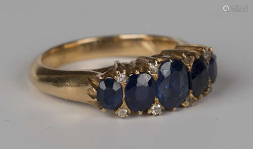 A gold, sapphire and diamond five stone ring, mounted with a row of cushion shaped sapphires