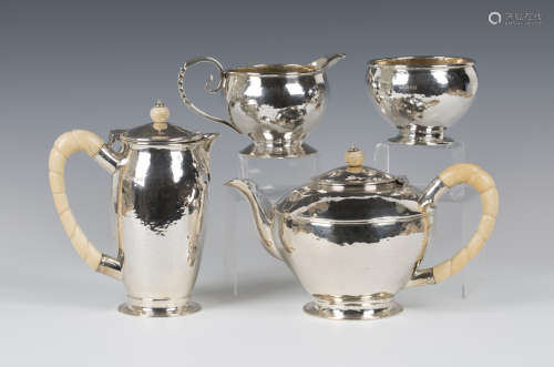 A George V silver four-piece tea set with hammered decoration, comprising teapot and hot water, each