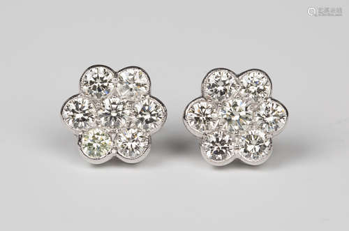 A pair of white gold and diamond cluster earrings, each collet set with seven circular cut diamonds,