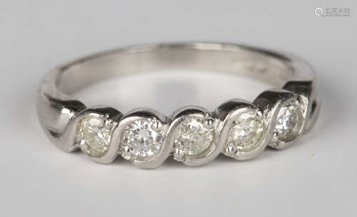 A platinum and diamond five stone ring, mounted with a row of circular cut diamonds in serpentine