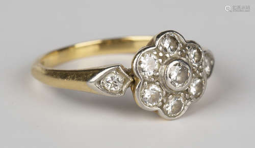 A gold and diamond seven stone cluster ring, mounted with a circular cut diamond between diamond