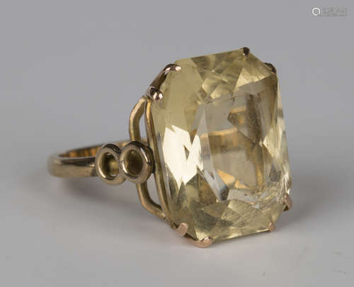 A gold ring, claw set with a cut-cornered rectangular scissor cut citrine between pierced shoulders,