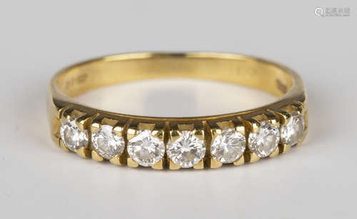 An 18ct gold and diamond seven stone half-hoop ring, mounted with a row of circular cut diamonds,