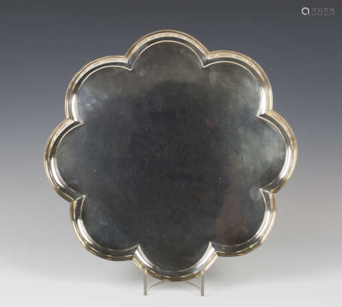 A George VI silver circular tray of raised petal shaped outline, on four reeded bracket feet, London