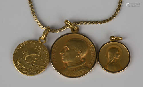 Three gold devotional pendants, each detailed '750', and a gold serpentine link neckchain,